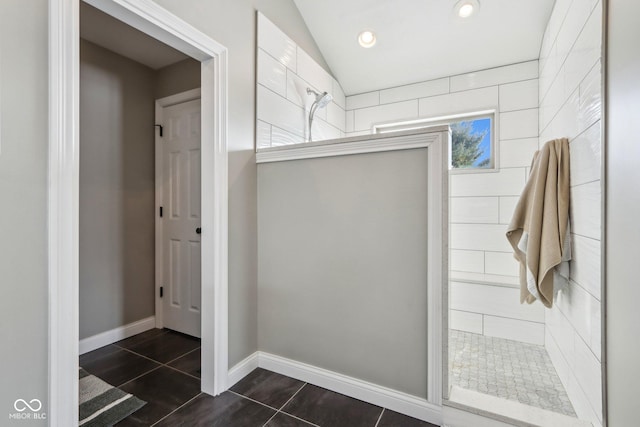 full bath featuring baseboards, tiled shower, recessed lighting, vaulted ceiling, and tile patterned floors