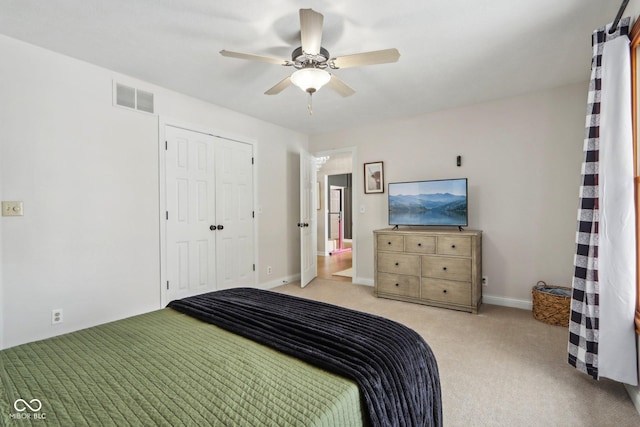 unfurnished bedroom with visible vents, a closet, baseboards, light colored carpet, and ceiling fan