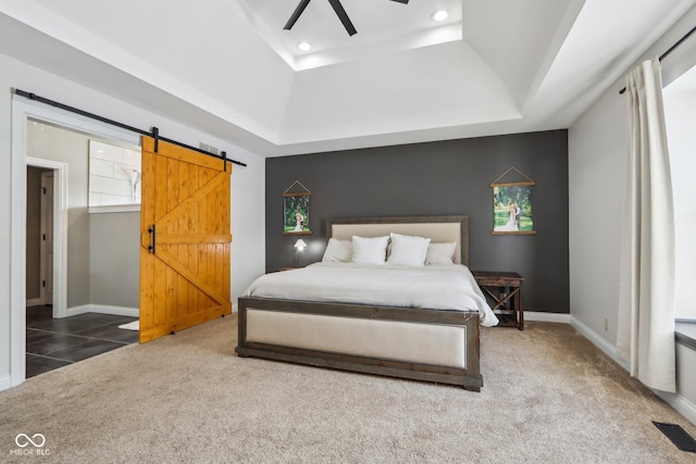 bedroom with a barn door, carpet flooring, baseboards, and visible vents