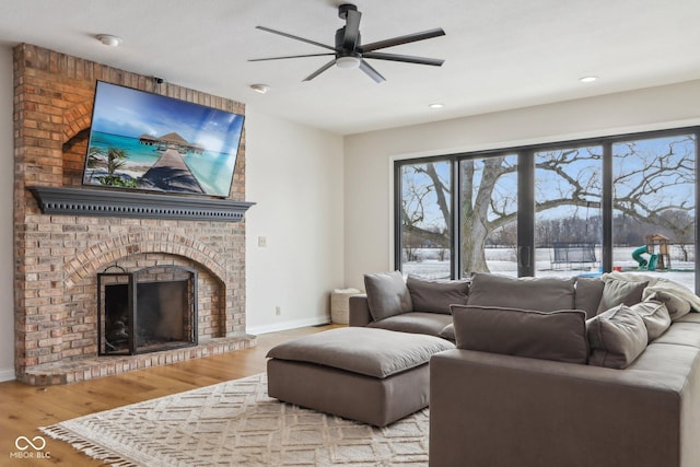 living area featuring wood finished floors, baseboards, a fireplace, recessed lighting, and ceiling fan