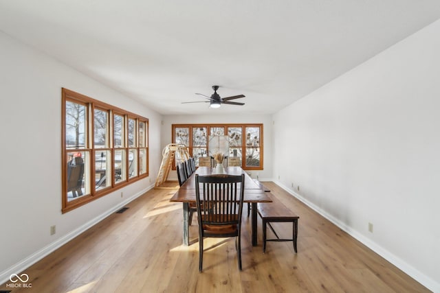 dining area with light wood-style flooring, baseboards, visible vents, and ceiling fan