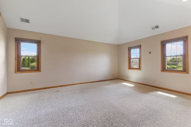 carpeted spare room with visible vents, baseboards, and plenty of natural light