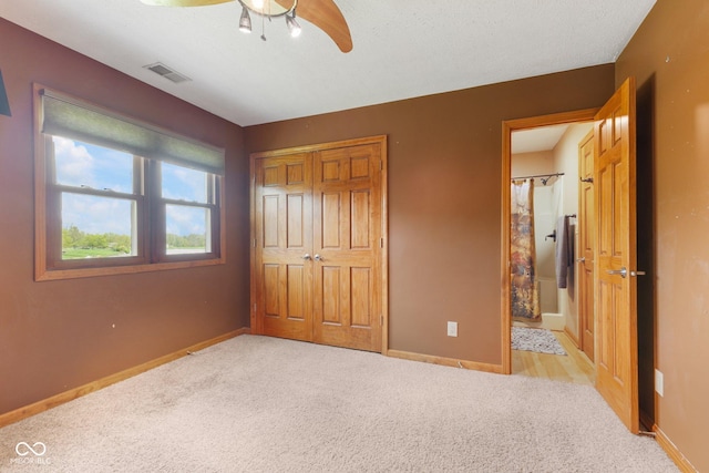 unfurnished bedroom with ceiling fan, visible vents, carpet floors, baseboards, and a closet