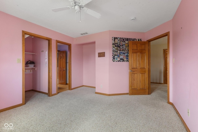unfurnished bedroom featuring carpet floors, baseboards, visible vents, and a spacious closet
