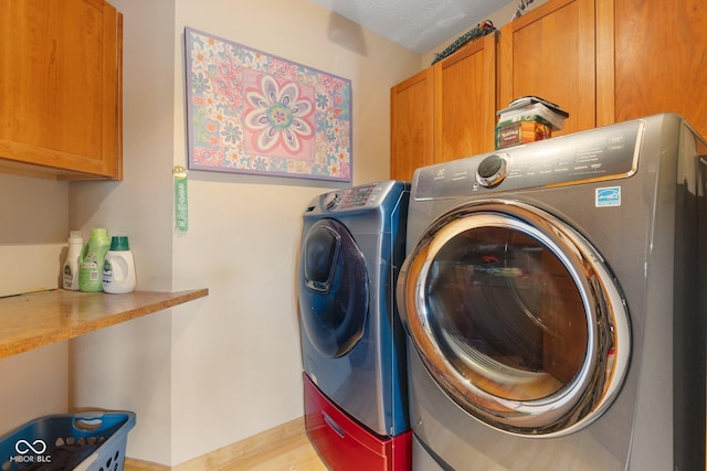 laundry area featuring cabinet space, baseboards, and washer and clothes dryer