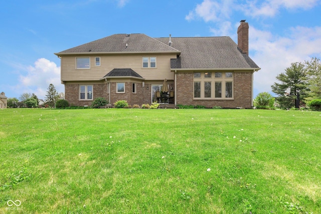 rear view of property featuring a lawn, brick siding, and a chimney