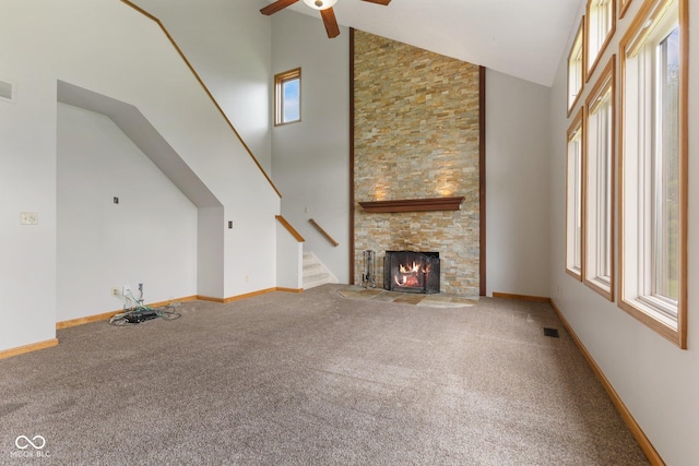 unfurnished living room featuring carpet floors, ceiling fan, plenty of natural light, and stairway