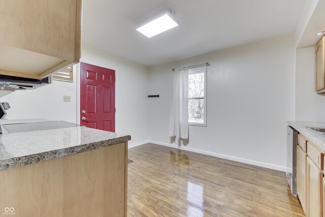 kitchen featuring baseboards, light brown cabinetry, light wood-type flooring, range, and stainless steel dishwasher