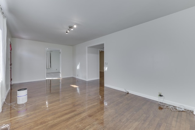 empty room featuring wood finished floors and baseboards