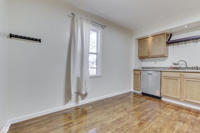 kitchen with light brown cabinetry, light wood-style flooring, dishwasher, and a sink