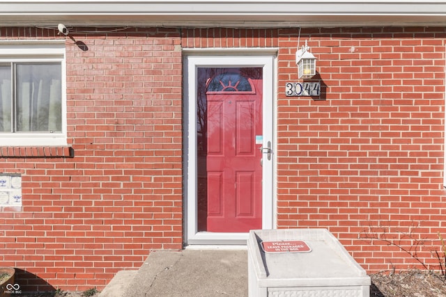 property entrance featuring brick siding