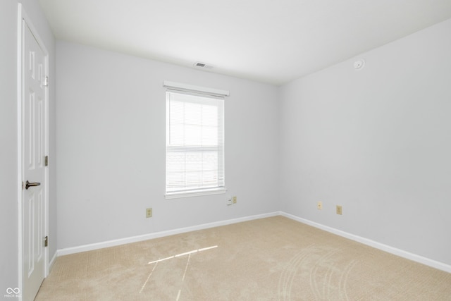 spare room featuring visible vents, baseboards, and light colored carpet