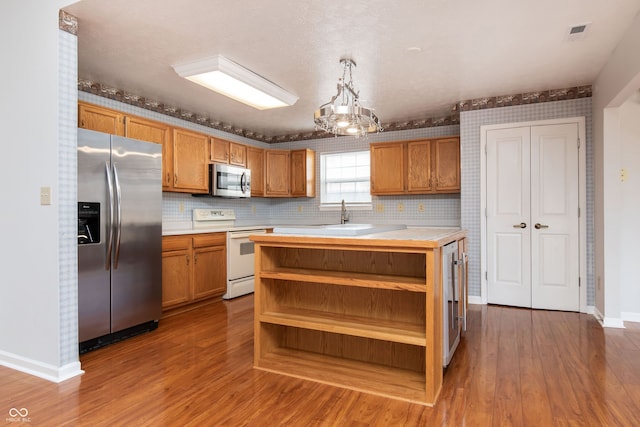 kitchen with visible vents, light countertops, appliances with stainless steel finishes, wood finished floors, and open shelves