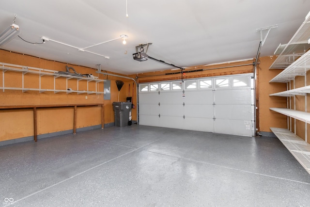 garage with electric panel and a garage door opener