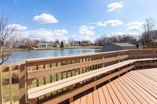 deck featuring a residential view, a water view, a storage shed, and an outdoor structure