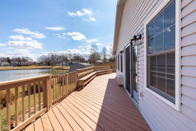 wooden terrace with a water view and an outdoor structure