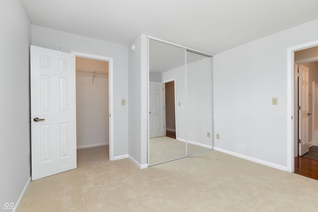 unfurnished bedroom featuring light carpet and baseboards