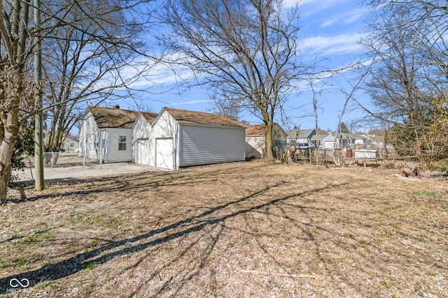 view of yard featuring an outbuilding, a garage, and a residential view