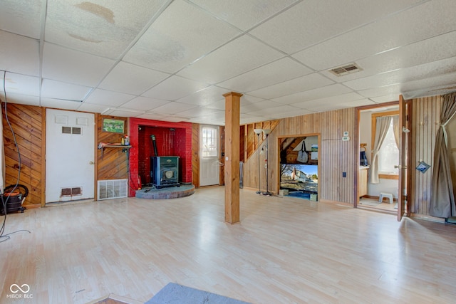 interior space with visible vents, wood finished floors, and a wood stove