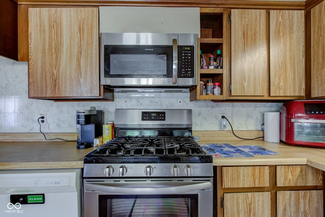 kitchen with decorative backsplash, light countertops, and appliances with stainless steel finishes