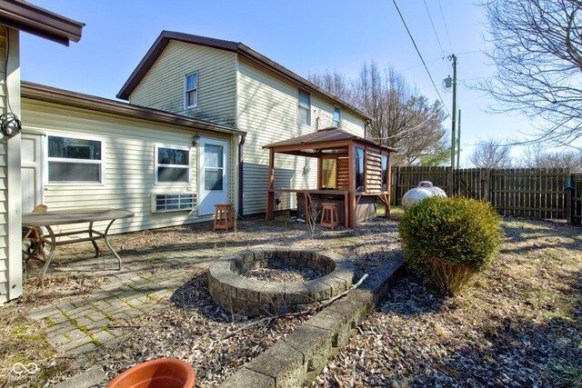 back of house with a gazebo, a patio area, an outdoor fire pit, and fence