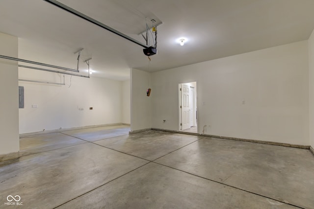 garage featuring electric panel, a garage door opener, and baseboards