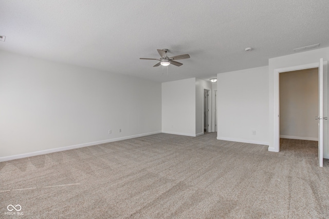 spare room featuring visible vents, a ceiling fan, a textured ceiling, carpet flooring, and baseboards