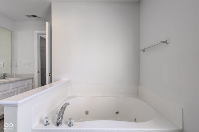 bathroom with visible vents, vanity, and a whirlpool tub