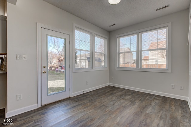 interior space with a healthy amount of sunlight, visible vents, and dark wood-style flooring