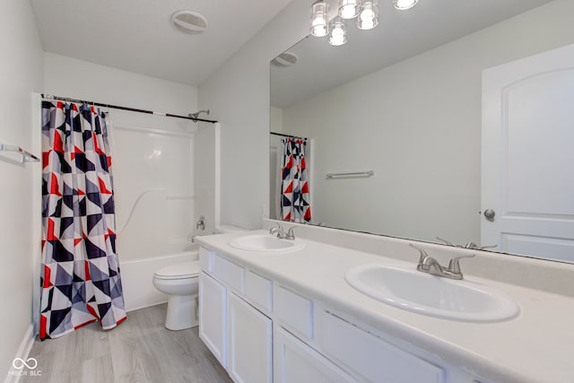 bathroom featuring double vanity, wood finished floors, visible vents, and a sink