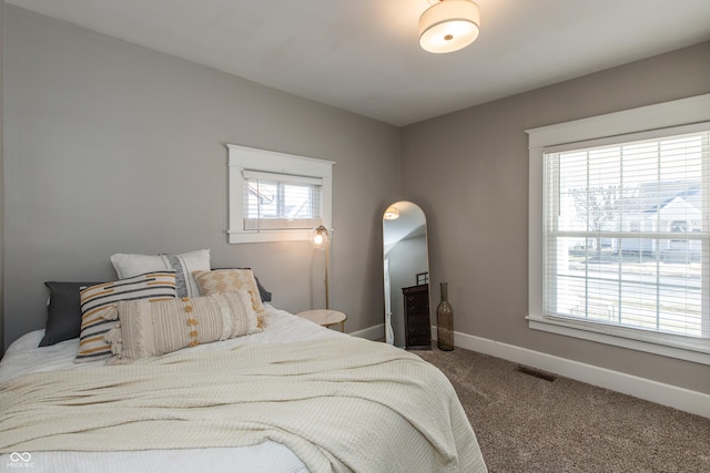 carpeted bedroom with visible vents and baseboards