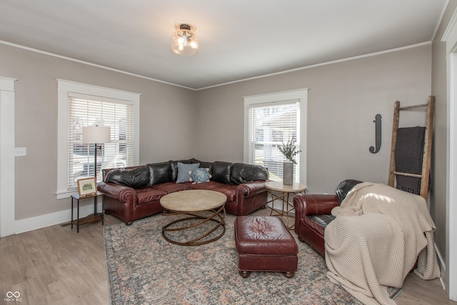 living room featuring crown molding, baseboards, and light wood-type flooring