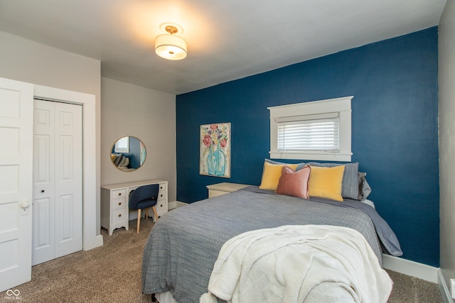 carpeted bedroom featuring baseboards and a closet