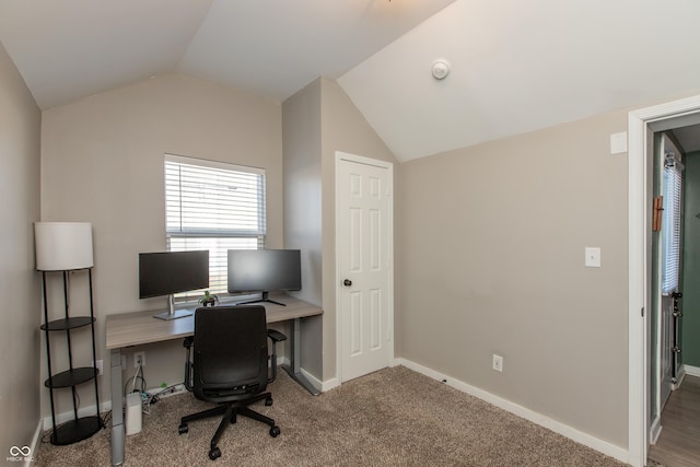 carpeted office space with lofted ceiling and baseboards