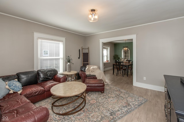 living area featuring crown molding, wood finished floors, and baseboards