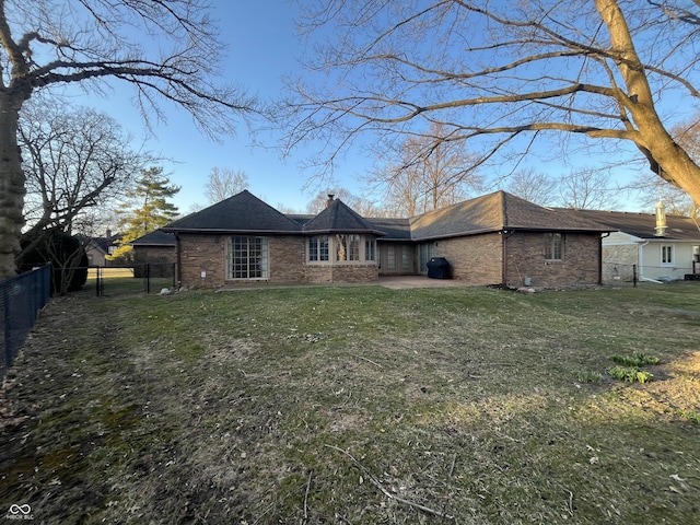 rear view of property with a gate, a yard, a fenced backyard, and brick siding