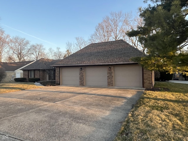 single story home featuring brick siding, driveway, an attached garage, and roof with shingles