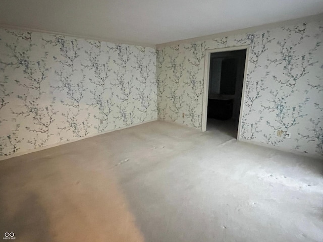 unfurnished room featuring wallpapered walls