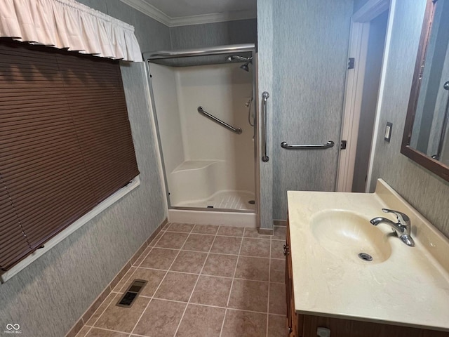 bathroom with visible vents, tile patterned flooring, crown molding, a shower stall, and vanity