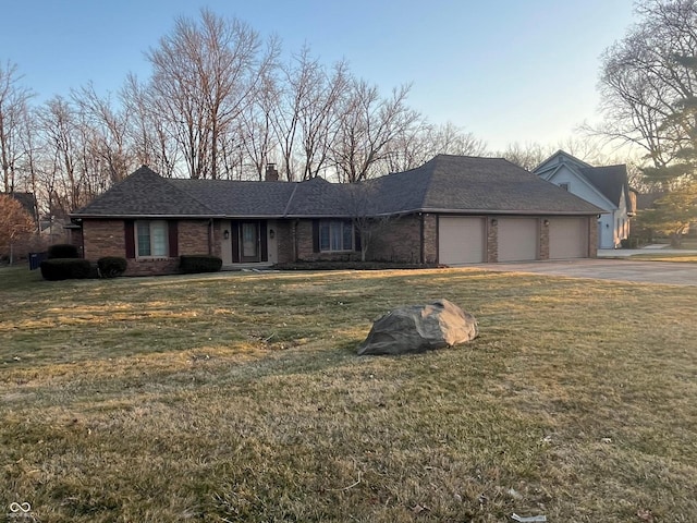 single story home with driveway, a chimney, a front lawn, a garage, and brick siding