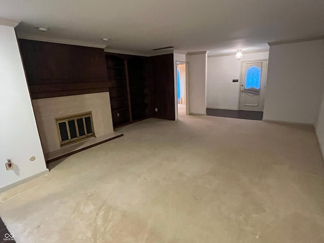 unfurnished living room featuring carpet flooring, built in features, a glass covered fireplace, and ornamental molding