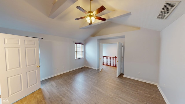 unfurnished bedroom featuring lofted ceiling, baseboards, visible vents, and light wood finished floors