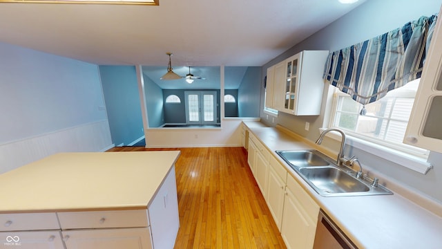 kitchen with a sink, light wood-style flooring, ceiling fan, and light countertops