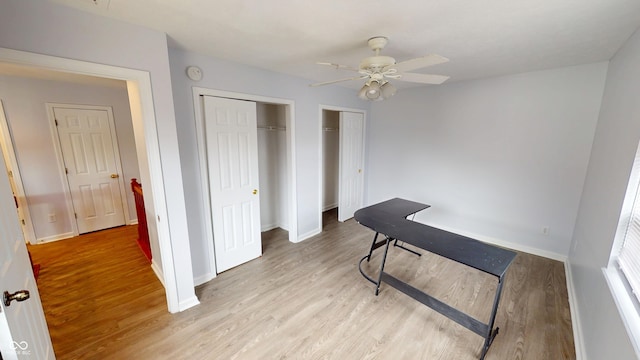 home office featuring baseboards, light wood-type flooring, and ceiling fan