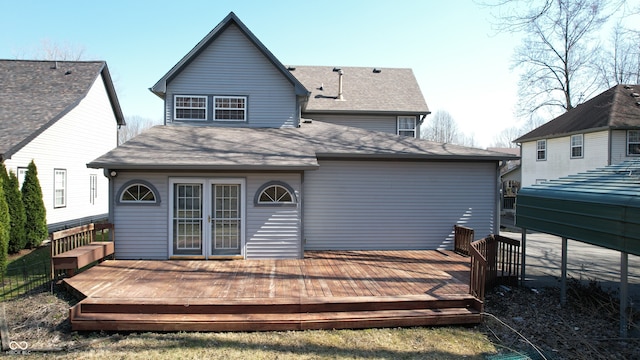 back of house featuring a shingled roof and a deck