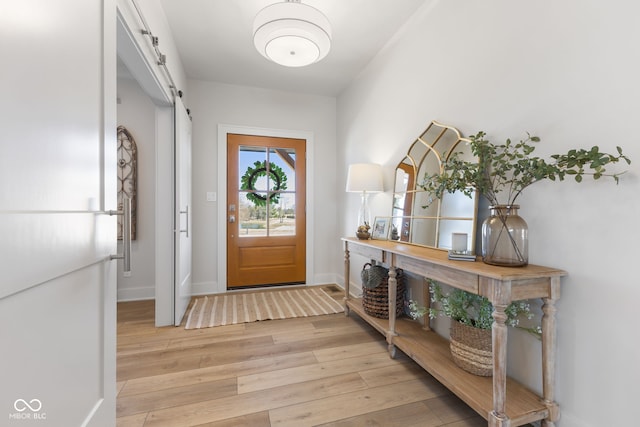 5189 Abbeygate Blvd, Bargersville, IN 46106 - foyer featuring a barn door, light wood-style flooring, and baseboards