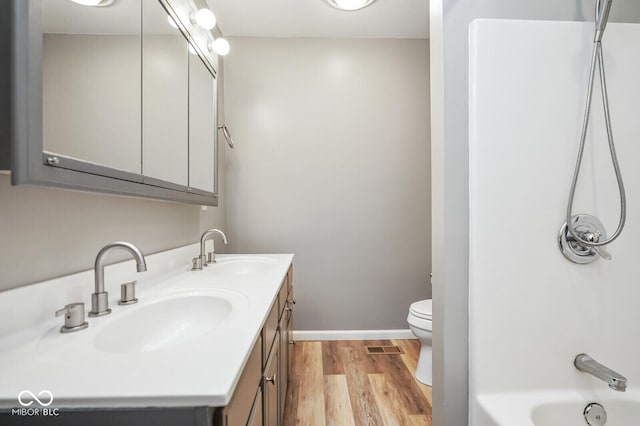 1310 Bowman Dr, Greenfield, IN 46140 - full bath featuring double vanity, toilet, wood finished floors, and a sink