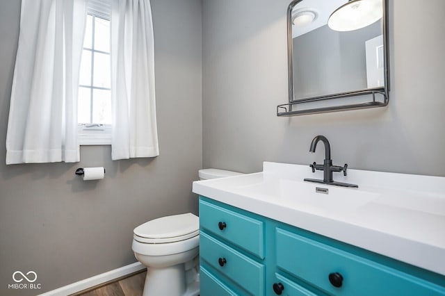 1310 Bowman Dr, Greenfield, IN 46140 - half bathroom with toilet, vanity, baseboards, and wood finished floors