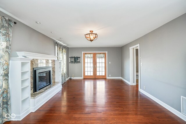 1310 Bowman Dr, Greenfield, IN 46140 - unfurnished living room with visible vents, wood finished floors, a high end fireplace, french doors, and baseboards