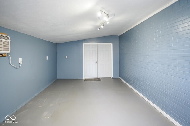 1310 Bowman Dr, Greenfield, IN 46140 - unfurnished bedroom featuring brick wall, a closet, concrete flooring, and a wall mounted AC